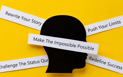 Motivational cards on a desk with words like Push, Make, The, Impossible, Possible